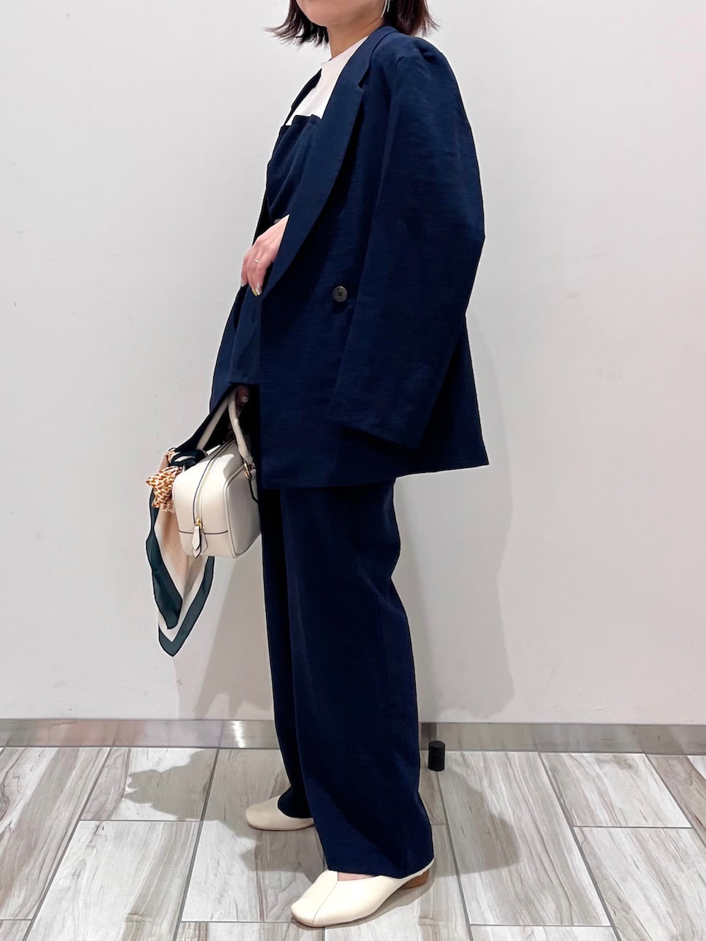 ホワイト系のボストンバッグ、ブルー系のTシャツ/カットソー、ブルー系のスラックスを着用したレディースの春コーディネートの2枚目の写真