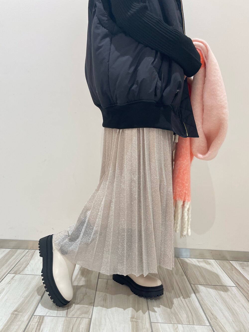 ブラック系のニット/セーター、ブラック系のブルゾン、シルバー系のスカートを着用したレディースの秋コーディネートの3枚目の写真