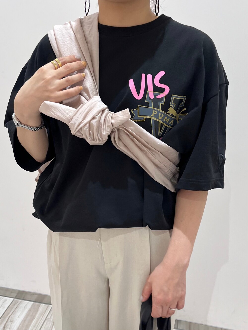 ブラック系のTシャツ/カットソー、ピンク系のシャツ/ブラウス、ホワイト系のスラックスを着用したレディースの春コーディネートの3枚目の写真