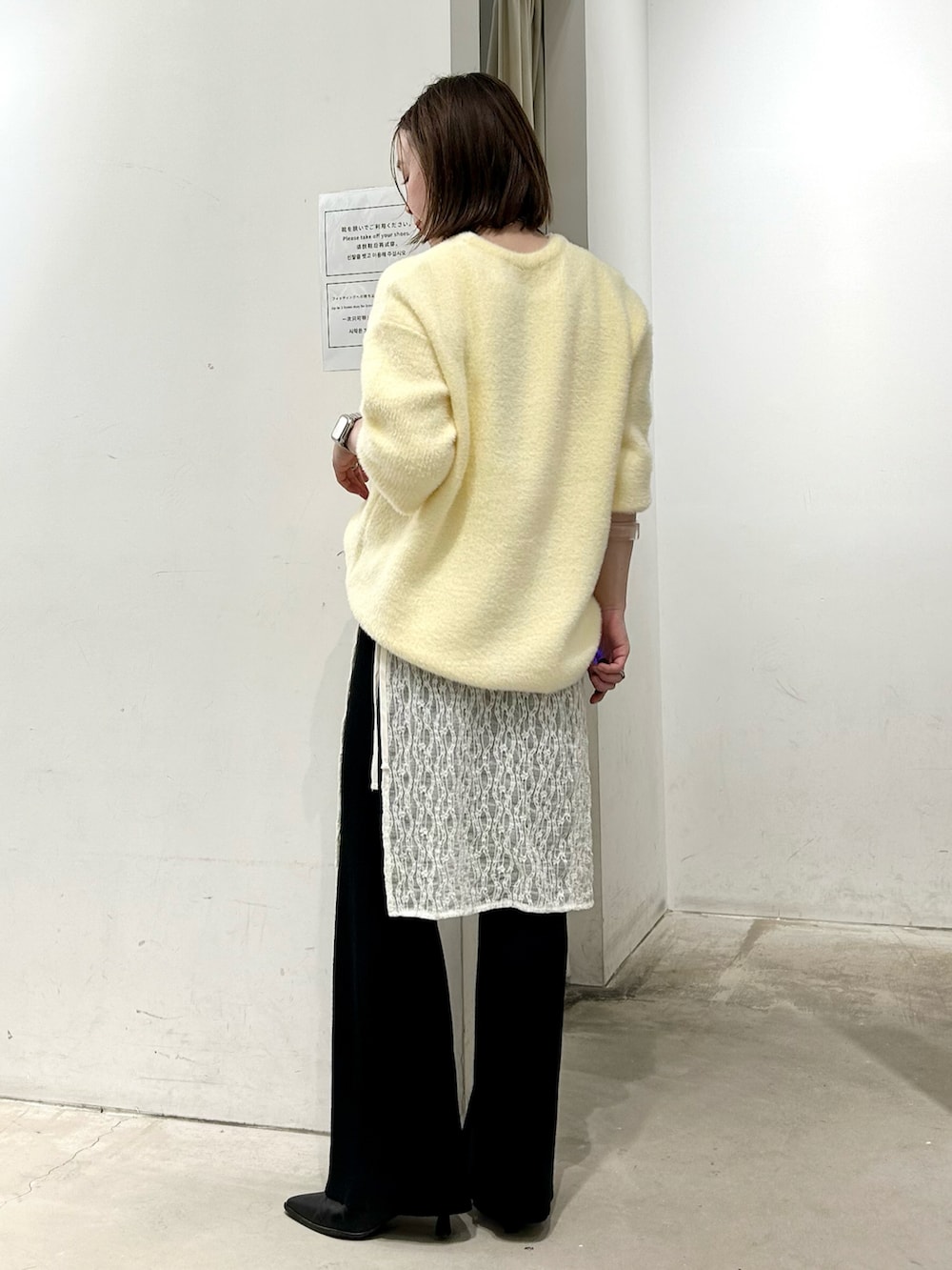 イエロー系のニット/セーター、ホワイト系のスカート、ブラック系のその他パンツを着用したレディースの冬コーディネートの3枚目の写真