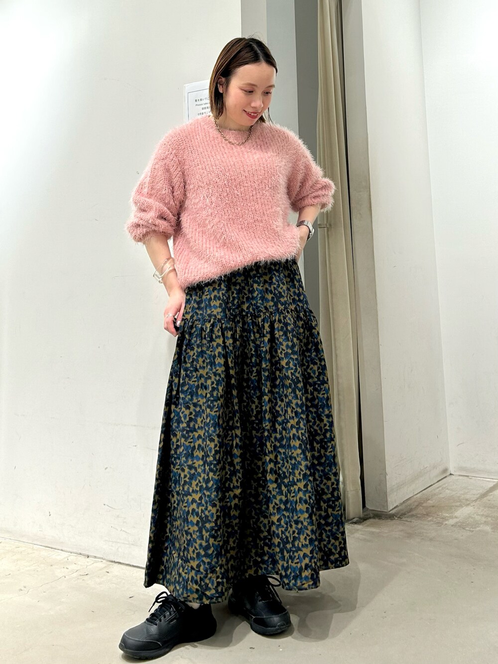 ピンク系のニット/セーター、イエロー系のスカートを着用したレディースの秋コーディネートの2枚目の写真