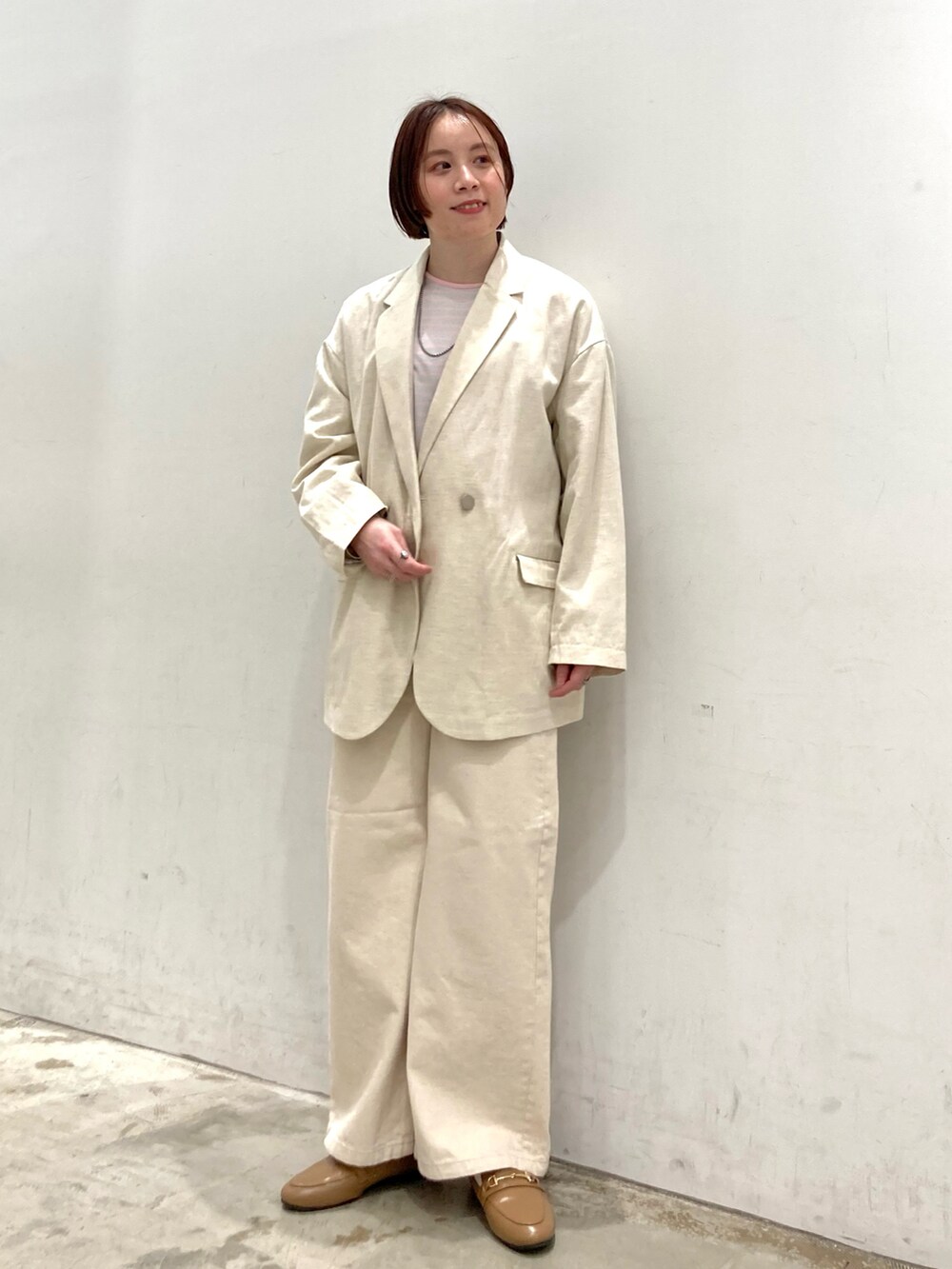 ピンク系のTシャツ/カットソー、ベージュ系のテーラードジャケット、ベージュ系のデニムパンツを着用したレディースの春コーディネートの2枚目の写真