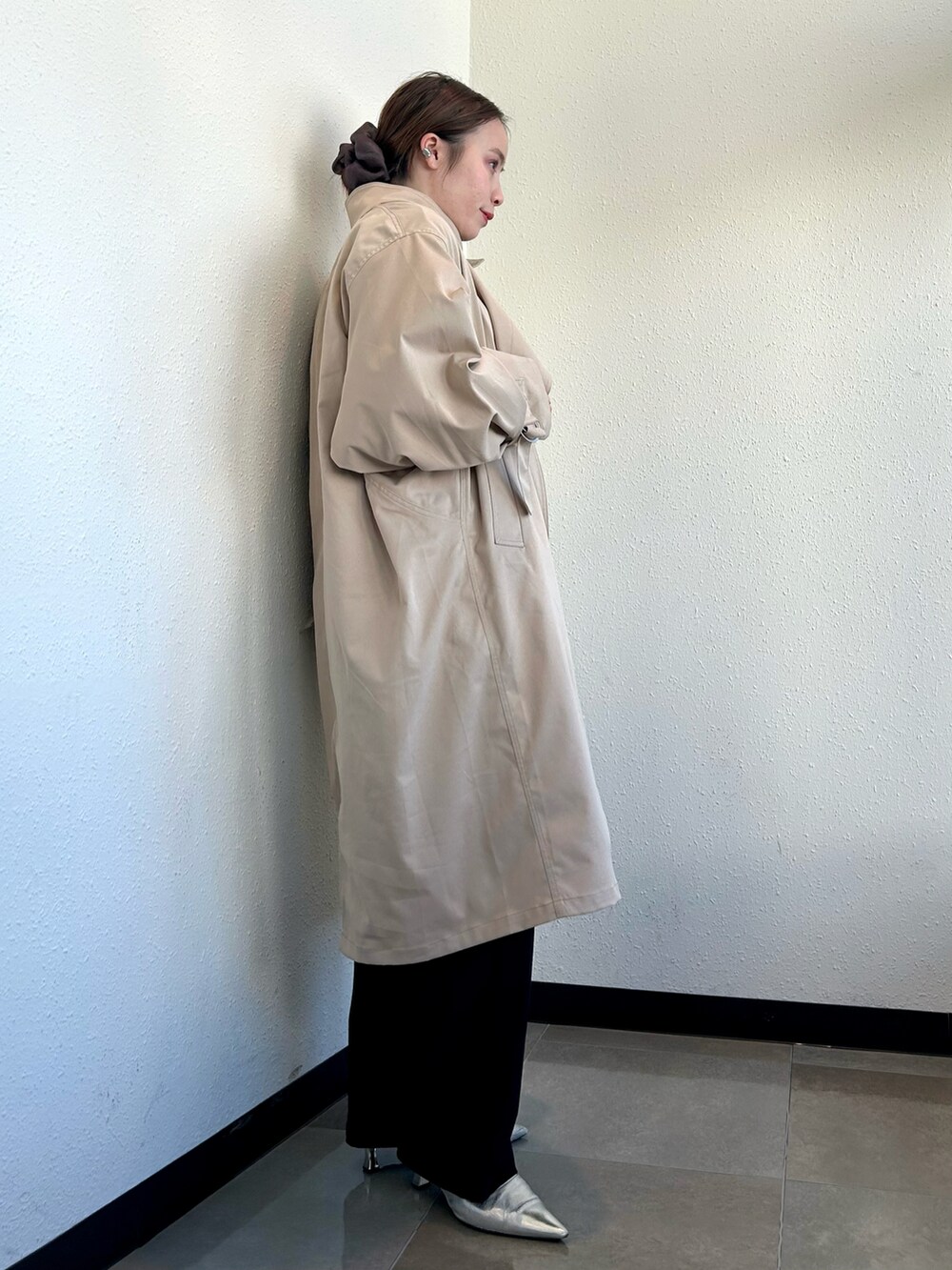 ホワイト系のスウェット、ベージュ系のトレンチコート、ブラック系のその他パンツを着用したレディースの冬コーディネートの2枚目の写真