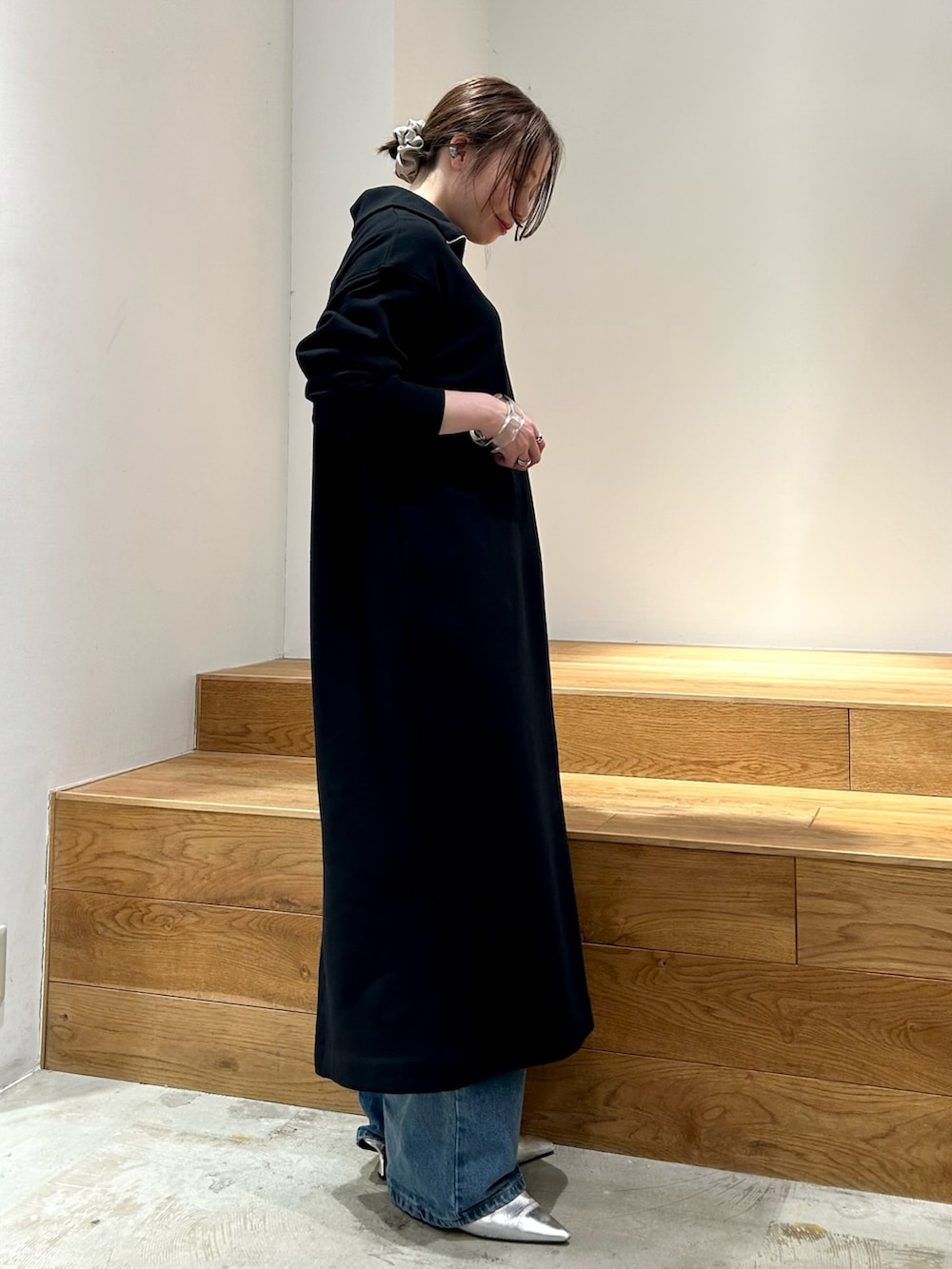 ブラック系のワンピース、ブルー系のデニムパンツを着用したレディースの冬コーディネートの2枚目の写真