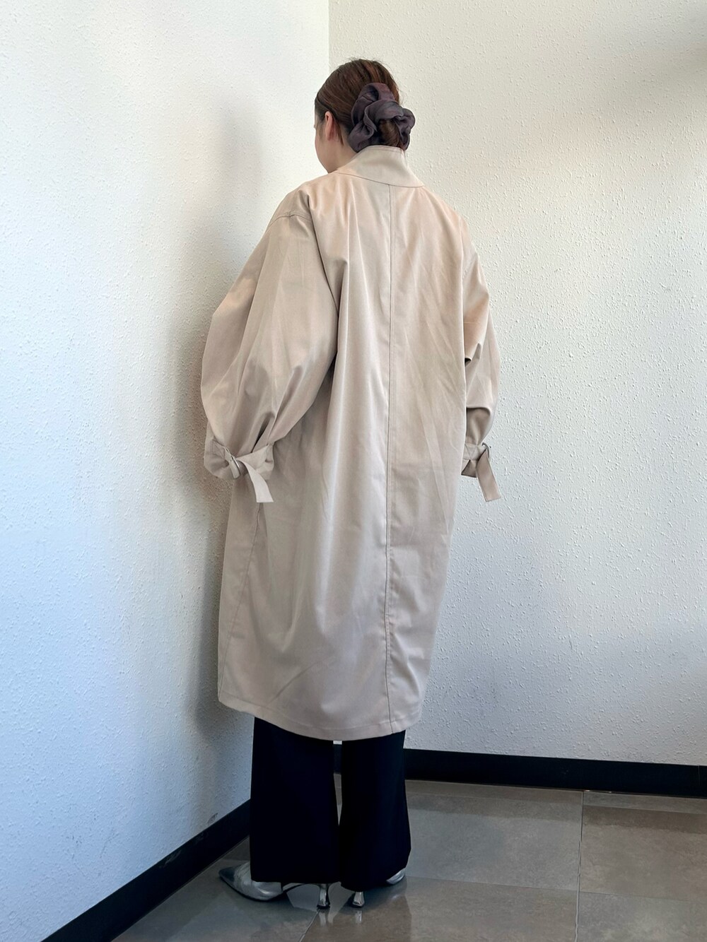 ホワイト系のスウェット、ベージュ系のトレンチコート、ブラック系のその他パンツを着用したレディースの冬コーディネートの3枚目の写真