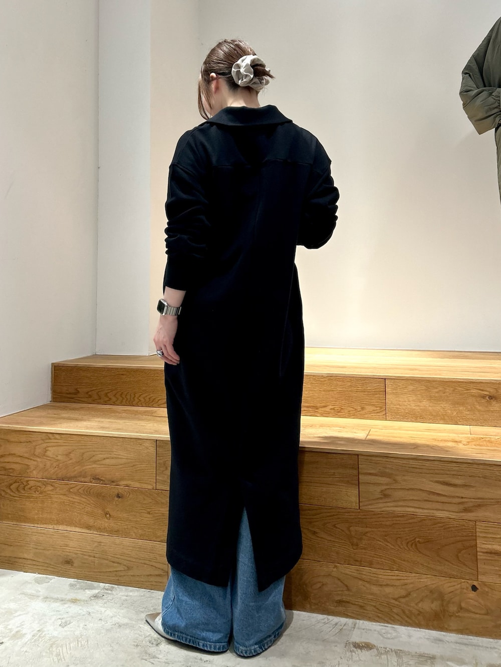 ブラック系のワンピース、ブルー系のデニムパンツを着用したレディースの冬コーディネートの3枚目の写真