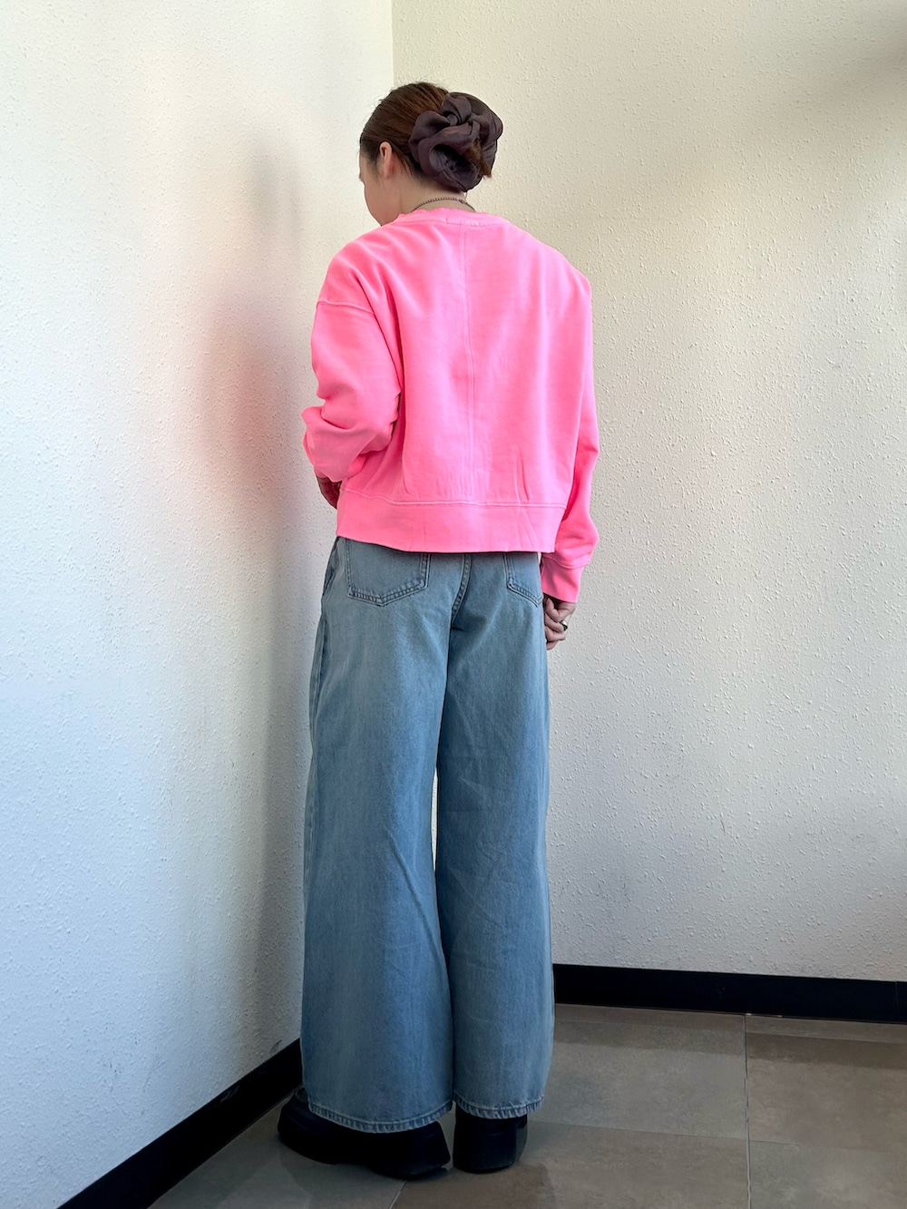 ブルー系のデニムパンツ、ピンク系のカーディガン/ボレロを着用したレディースの春コーディネートの3枚目の写真