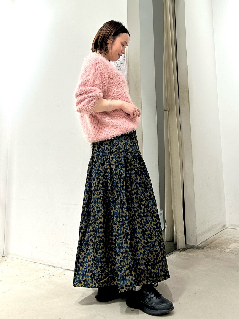 ピンク系のニット/セーター、イエロー系のスカートを着用したレディースの秋コーディネートの3枚目の写真