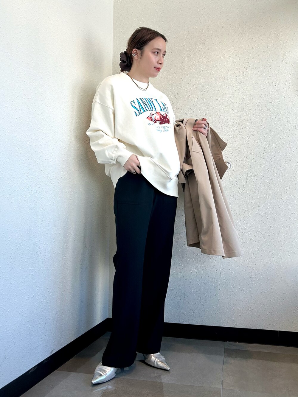 ホワイト系のスウェット、ベージュ系のトレンチコート、ブラック系のその他パンツを着用したレディースの冬コーディネートの5枚目の写真