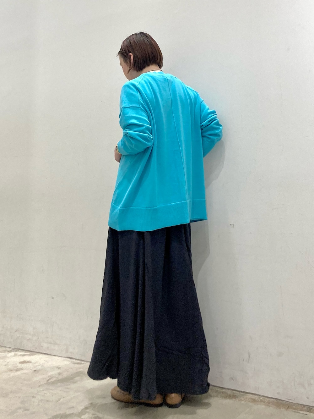 ブラック系のスカート、ブルー系のカーディガン/ボレロ、ホワイト系のTシャツ/カットソーを着用したレディースの春コーディネートの2枚目の写真