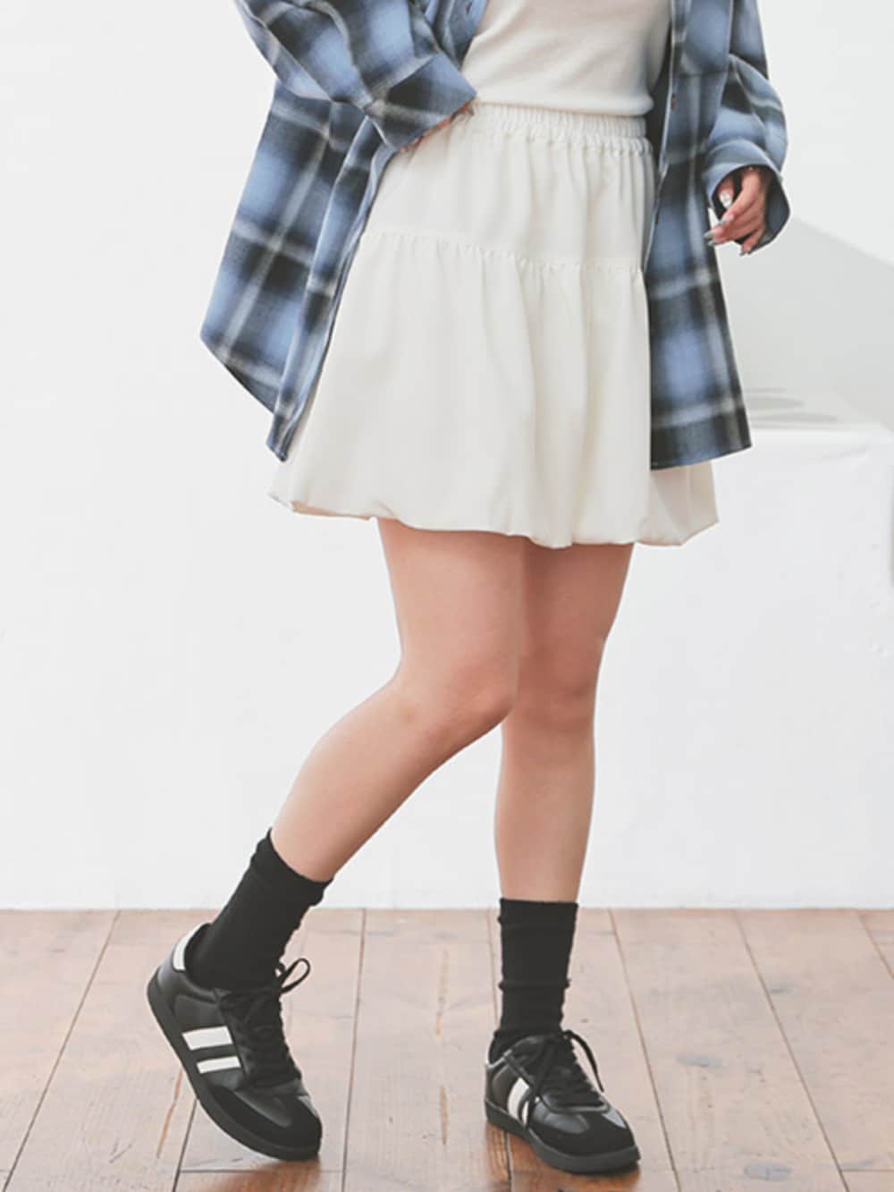 ブラック系のボストンバッグ、ホワイト系のスカート、ブルー系のシャツ/ブラウスを着用したレディースの秋コーディネートの2枚目の写真