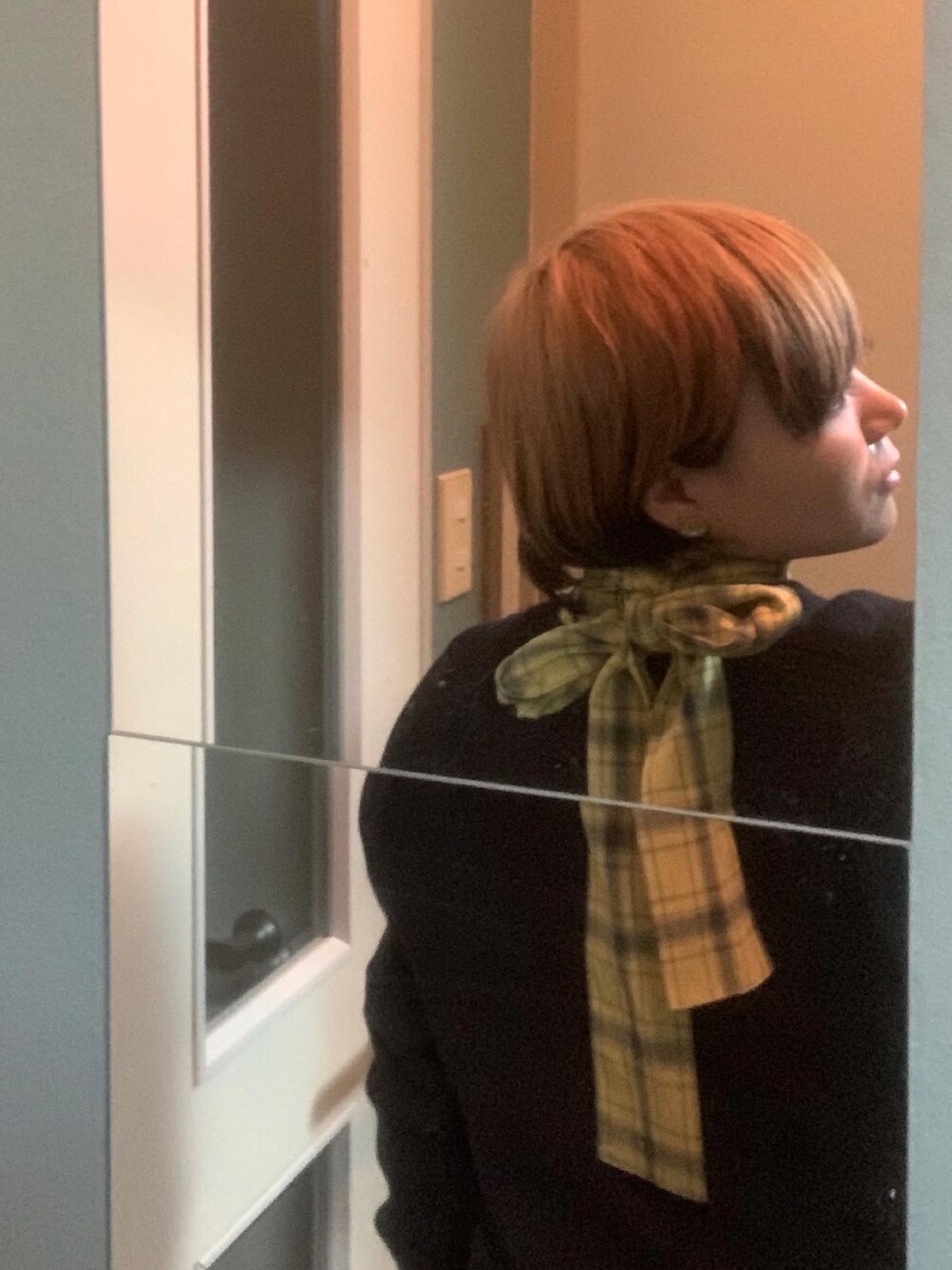 ブラック系のニット/セーター、イエロー系のシャツ/ブラウス、ブラウン系のムートンコートを着用したレディースの夏コーディネートの2枚目の写真