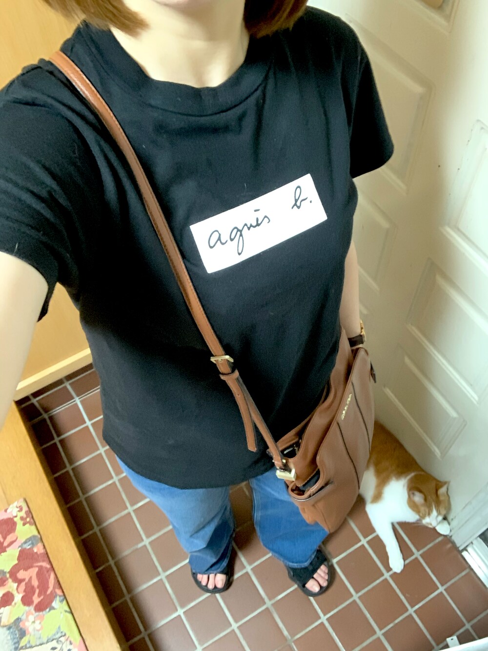 ブラック系のTシャツ/カットソー、ブラウン系のショルダーバッグ、ブルー系のデニムパンツを着用したレディースの夏コーディネートの2枚目の写真