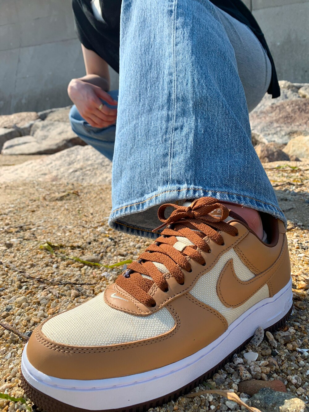 ブラック系のベスト、ホワイト系のキャミソール、ブラウン系のショルダーバッグを着用したレディースの夏コーディネートの2枚目の写真