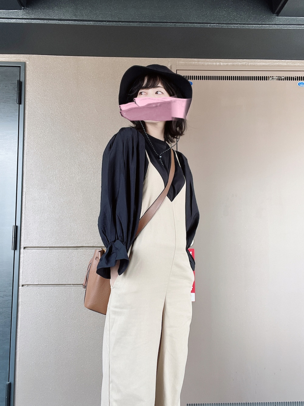 ベージュ系のサロペット/オーバーオール、ブラック系のTシャツ/カットソー、ブラウン系のサンダルを着用したレディースの秋コーディネートの2枚目の写真