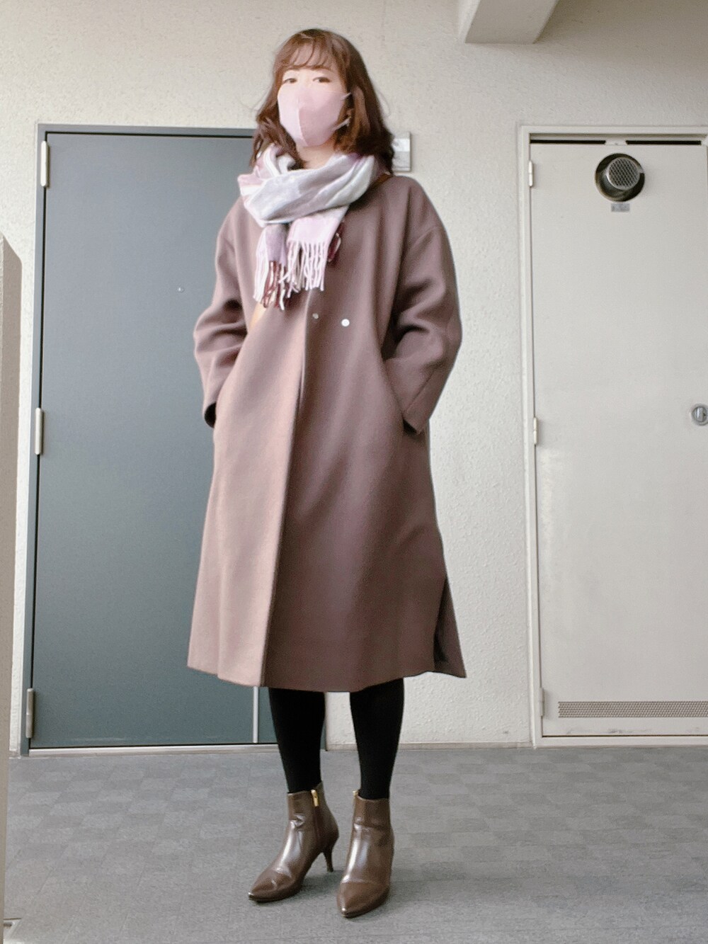 ブラウン系のブーツ、ブラック系のワンピース、ブラウン系のノーカラーコートを着用したレディースの冬コーディネートの3枚目の写真