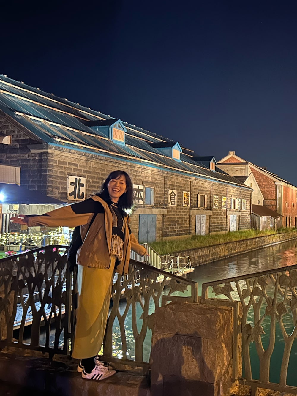 ホワイト系のスニーカー、イエロー系のスカート、ブラック系のベストを着用したレディースの夏コーディネートの2枚目の写真