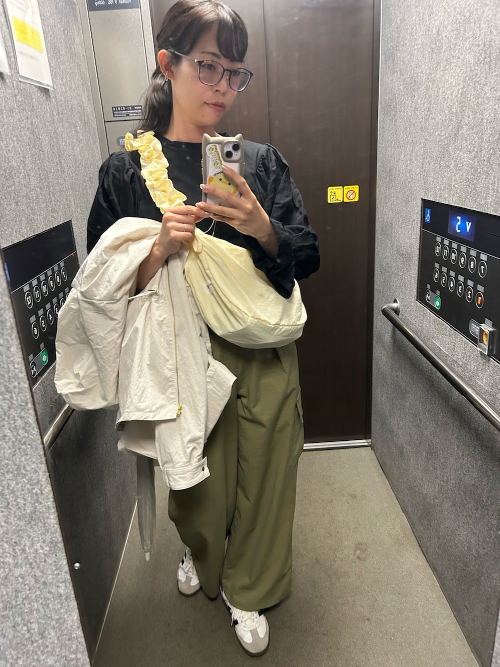 ホワイト系のスニーカー、グリーン系のカーゴパンツ、ホワイト系のブルゾンを着用したレディースの春コーディネートの2枚目の写真