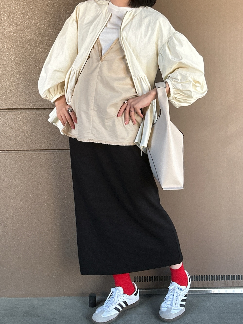ホワイト系のスニーカー、ブラック系のスカート、ホワイト系のハンドバッグを着用したレディースの春コーディネートの4枚目の写真