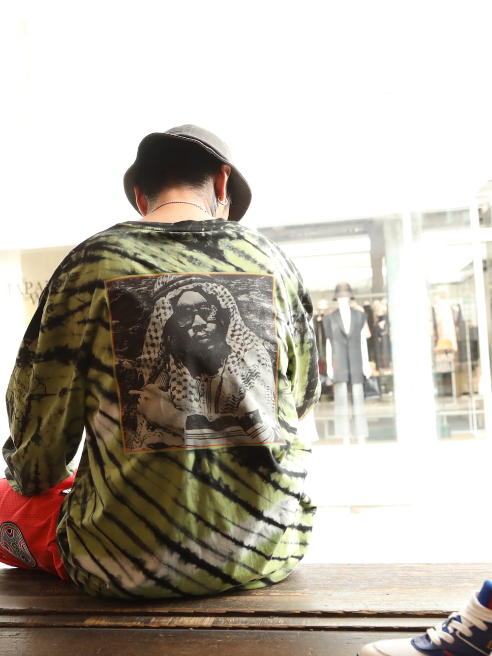 イエロー系のTシャツ/カットソー、レッド系のその他パンツ、グレー系のハットを着用したメンズの夏コーディネートの5枚目の写真