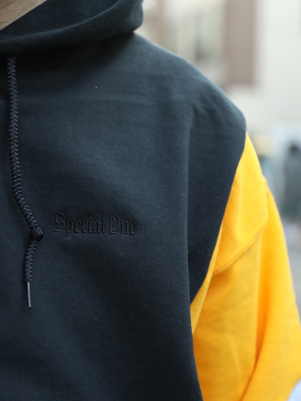 ブラック系のベスト、ブラック系のパーカー、ブルー系のデニムパンツを着用したメンズの春コーディネートの5枚目の写真