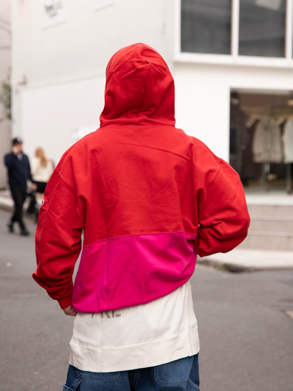 レッド系のパーカー、ホワイト系のTシャツ/カットソー、ブルー系のデニムパンツを着用したメンズの春コーディネートの4枚目の写真
