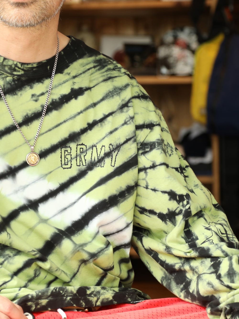 イエロー系のTシャツ/カットソー、レッド系のその他パンツ、グレー系のハットを着用したメンズの夏コーディネートの2枚目の写真