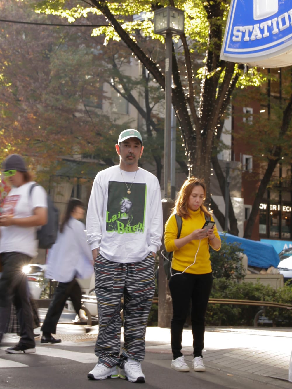 ホワイト系のビジネスシャツ、ブラック系のその他パンツ、ホワイト系のスニーカーを着用したメンズの秋コーディネートの3枚目の写真