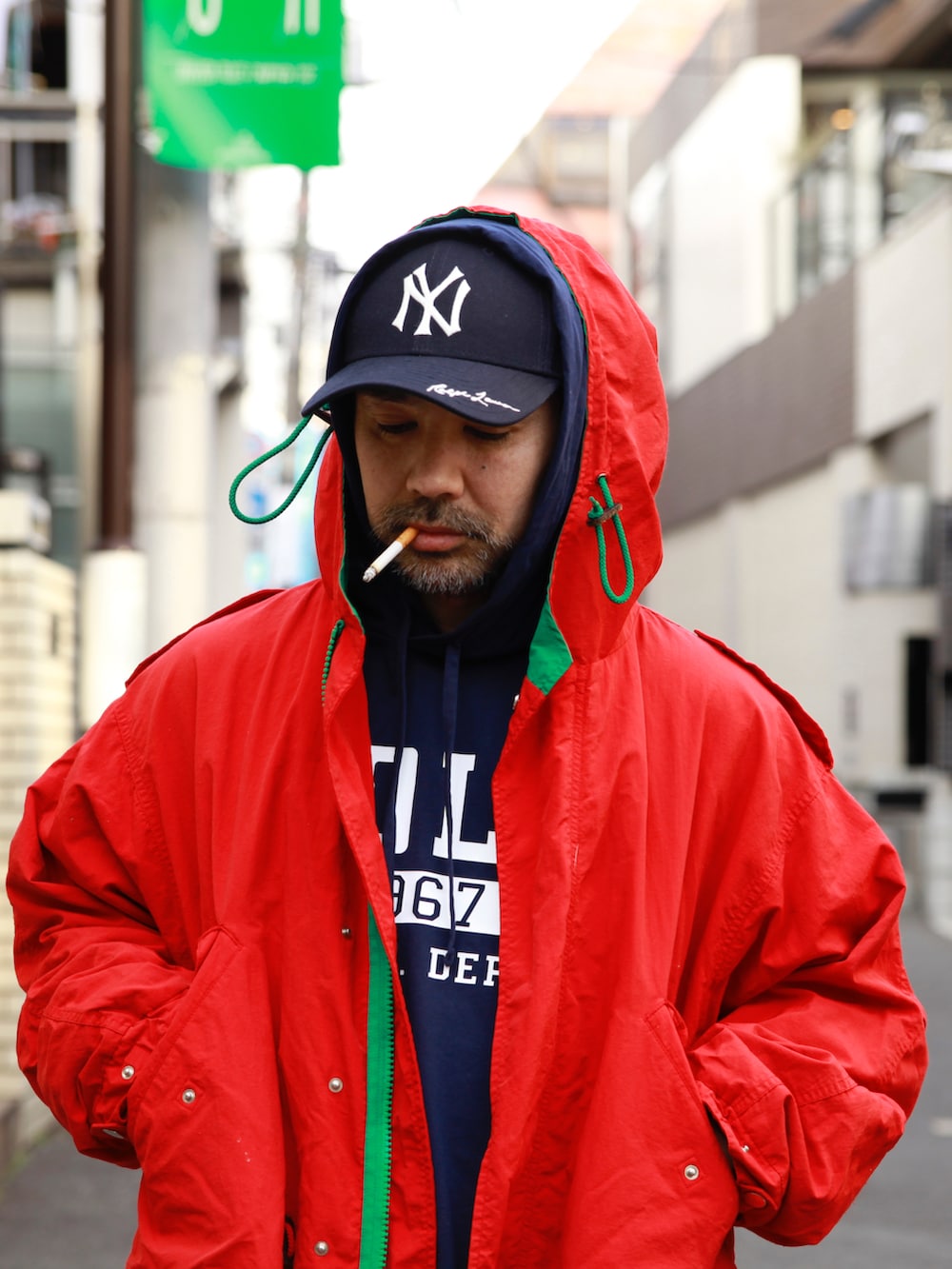 ブルー系のTシャツ/カットソー、レッド系のモッズコート、ブルー系のデニムパンツを着用したメンズの春コーディネートの3枚目の写真