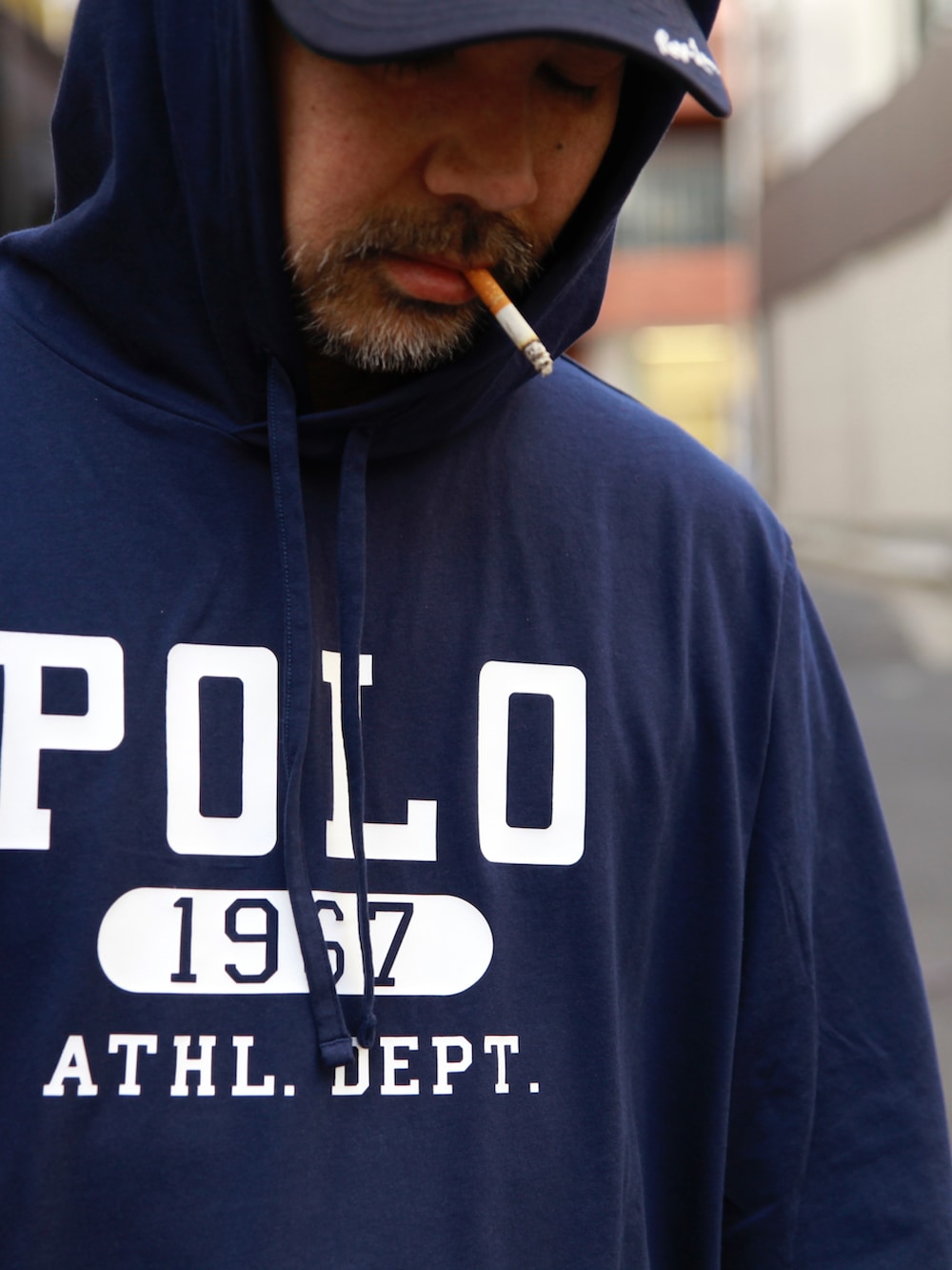 ブルー系のTシャツ/カットソー、レッド系のモッズコート、ブルー系のデニムパンツを着用したメンズの春コーディネートの5枚目の写真