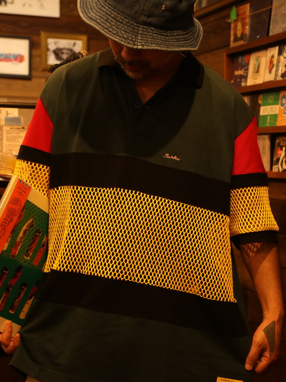 その他のポロシャツ、ベージュ系のチノパンツ、ブルー系のハットを着用したメンズの夏コーディネートの3枚目の写真