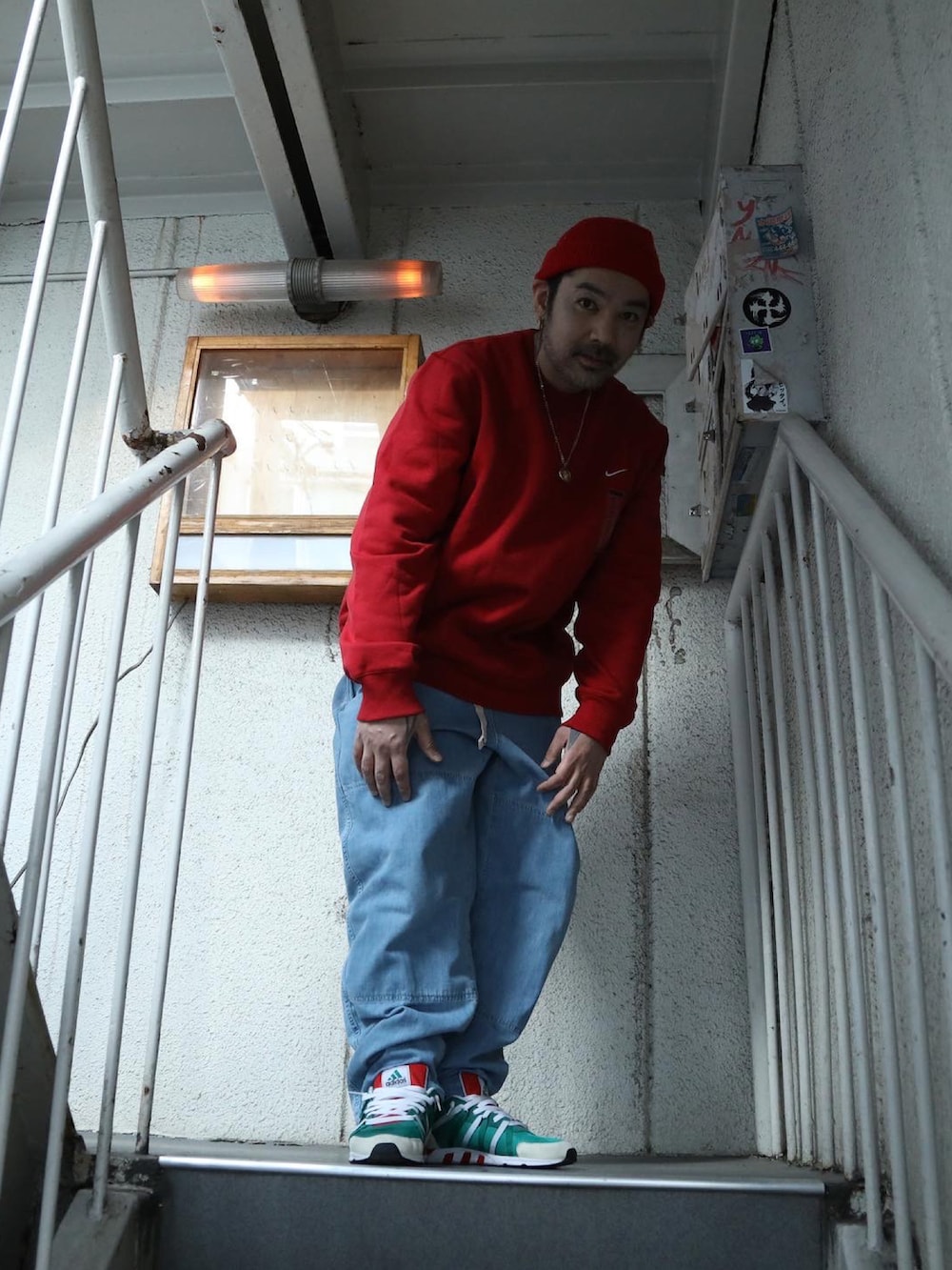 ブルー系のスタジャン、レッド系のスウェット、ブルー系のデニムパンツを着用したメンズの冬コーディネートの5枚目の写真