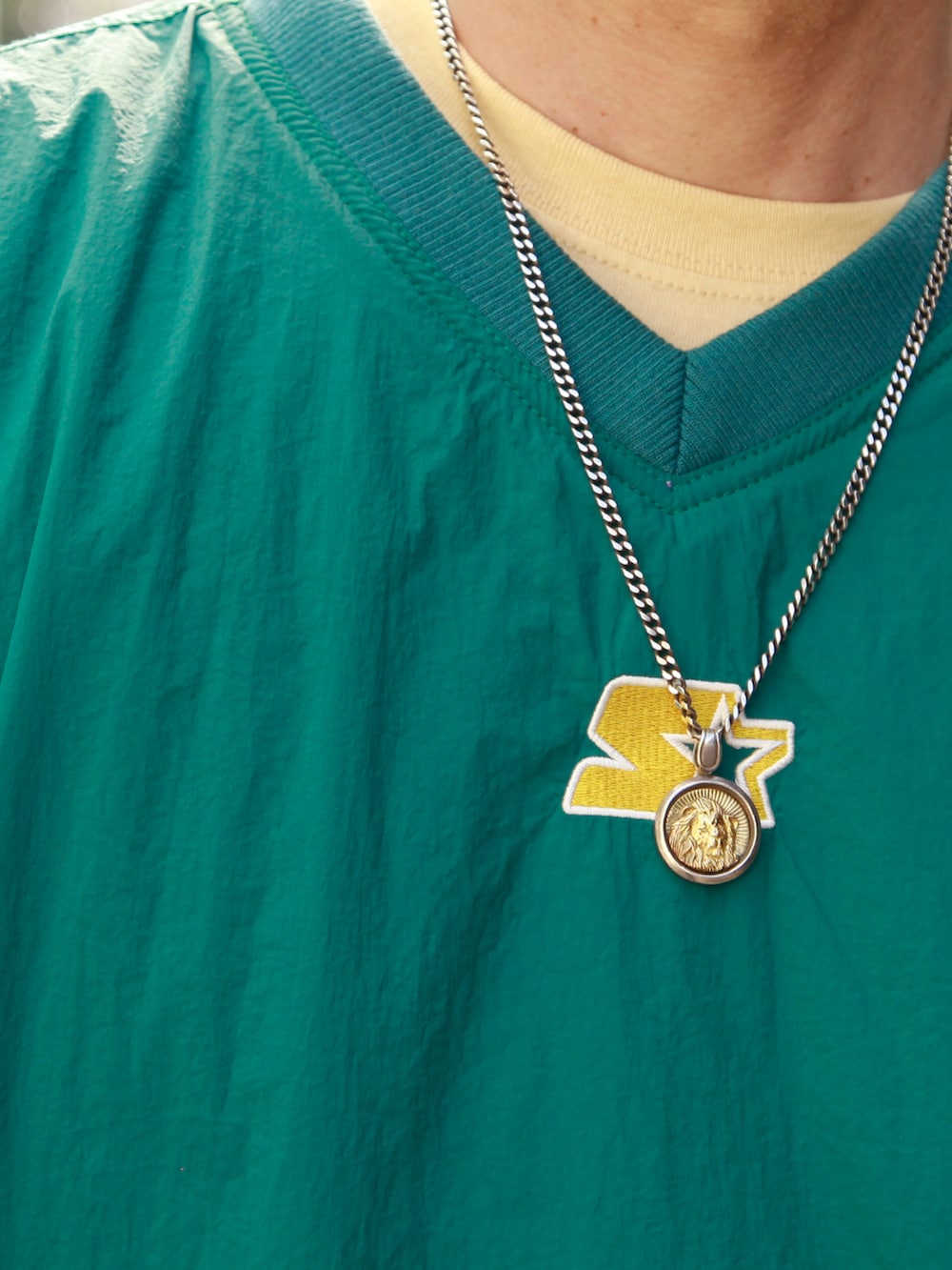 グリーン系のナイロンジャケット、グレー系のスウェットパンツ、ホワイト系のスニーカーを着用したメンズの秋コーディネートの3枚目の写真