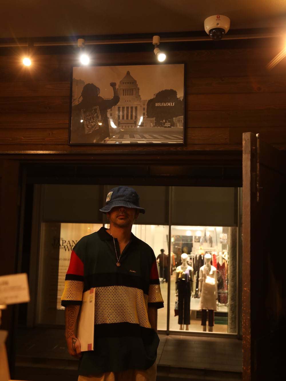 その他のポロシャツ、ベージュ系のチノパンツ、ブルー系のハットを着用したメンズの夏コーディネートの2枚目の写真