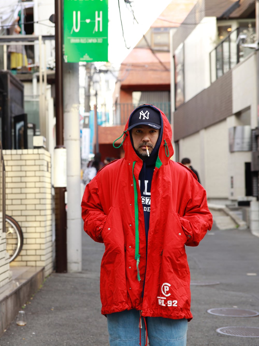 ブルー系のTシャツ/カットソー、レッド系のモッズコート、ブルー系のデニムパンツを着用したメンズの春コーディネートの2枚目の写真