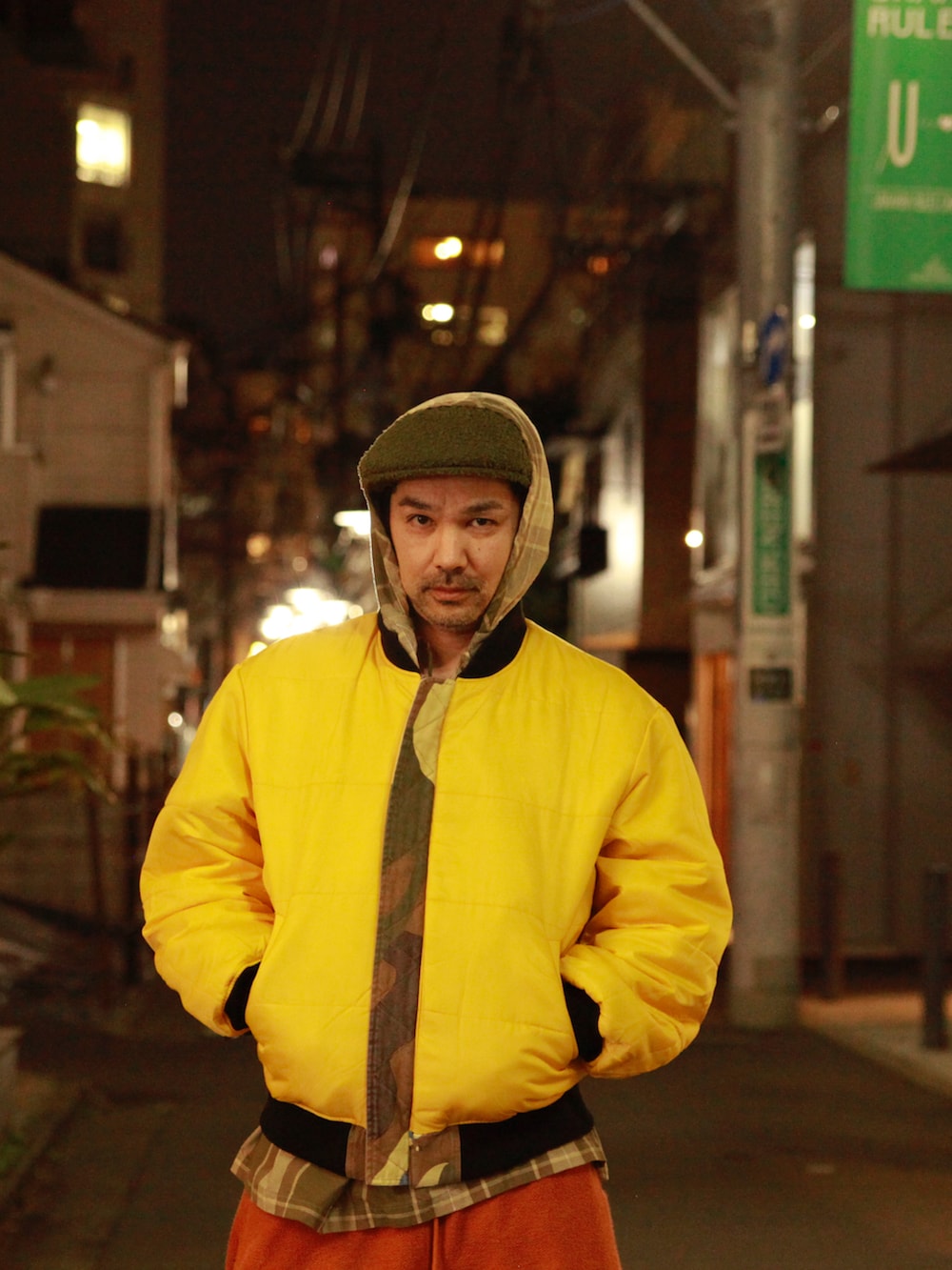 グリーン系のMA-1、ベージュ系のシャツ/ブラウス、オレンジ系のスウェットパンツを着用したメンズの春コーディネートの3枚目の写真