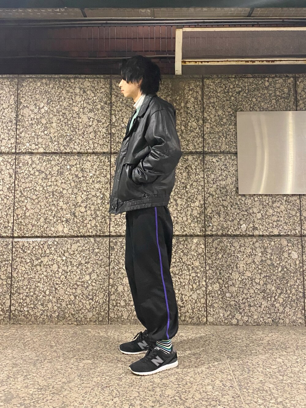 ブラック系のライダースジャケット、ブラック系のパンツ、ブラック系のスニーカーを着用したメンズの冬コーディネートの2枚目の写真