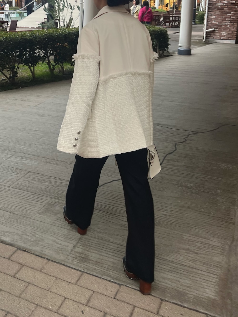 ホワイト系のテーラードジャケット、ブラック系のブーツ、ブルー系のニット/セーターを着用したレディースの冬コーディネートの3枚目の写真