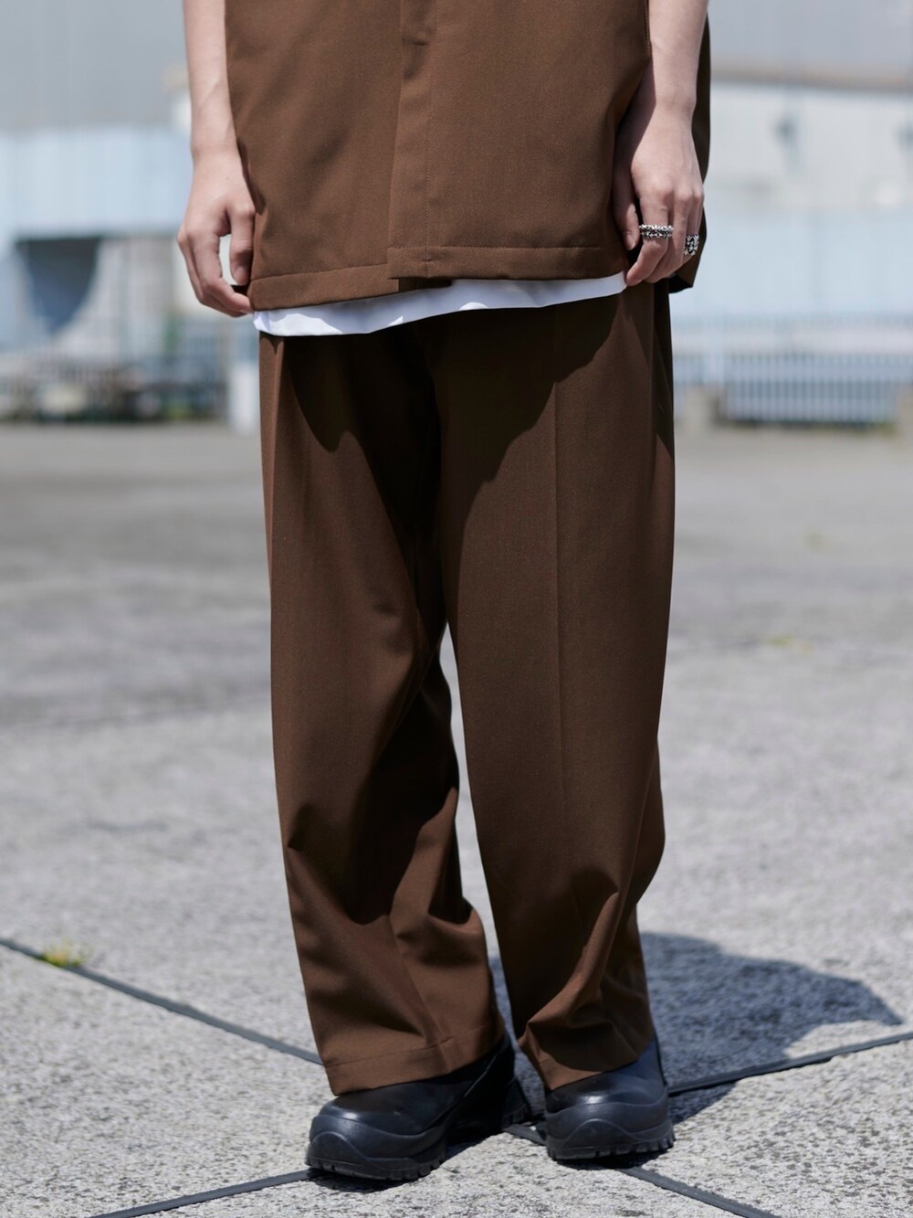 ブラウン系のスラックスを着用したメンズの春コーディネートの4枚目の写真