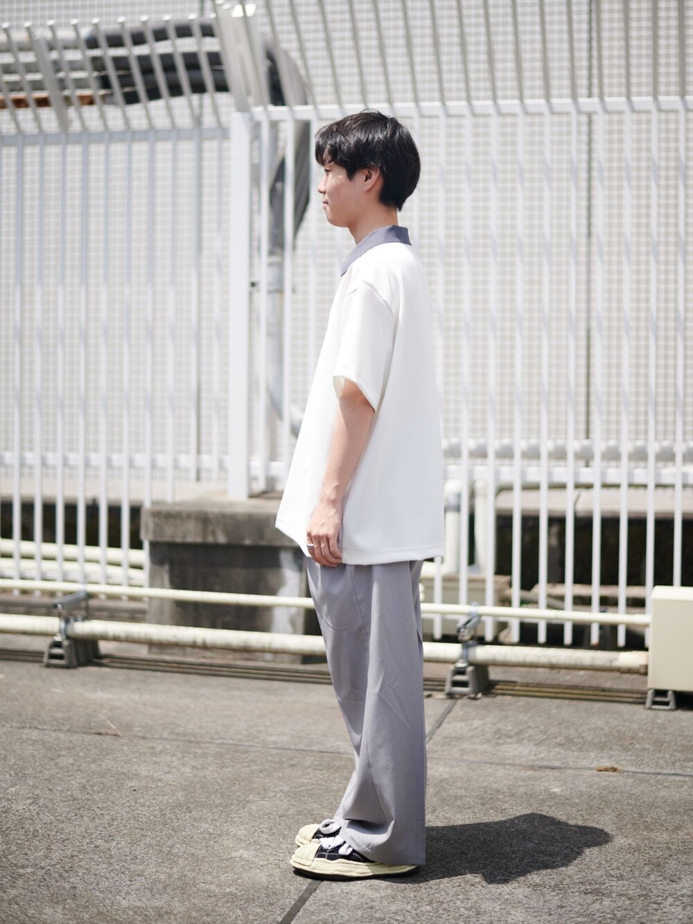 グレー系のスラックスを着用したメンズの夏コーディネートの2枚目の写真