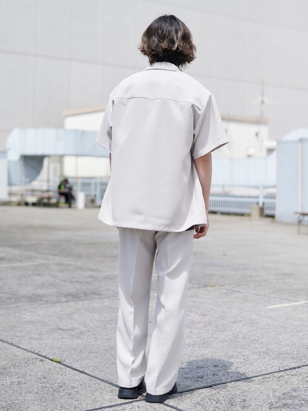 ホワイト系のテーラードジャケット、ホワイト系のスラックスを着用したメンズの春コーディネートの5枚目の写真