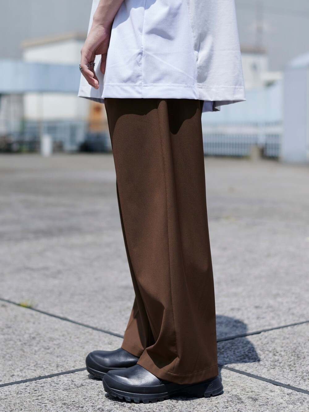 ブラウン系のスラックスを着用したメンズの春コーディネートの2枚目の写真