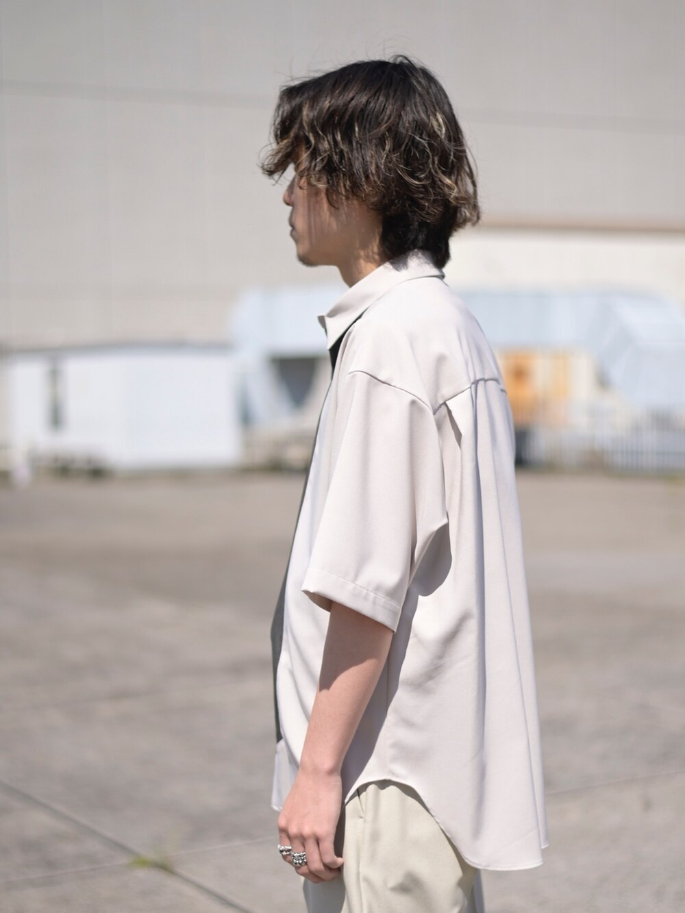 ベージュ系のスラックスを着用したメンズの夏コーディネートの3枚目の写真