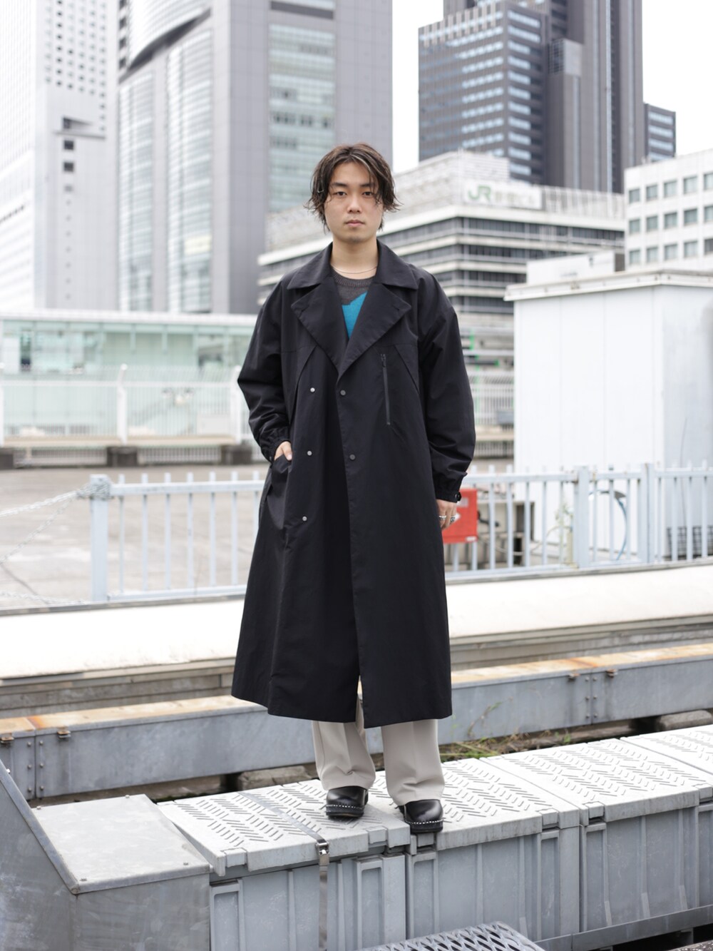 ブラック系のチェスターコートを着用したメンズの秋コーディネートの4枚目の写真