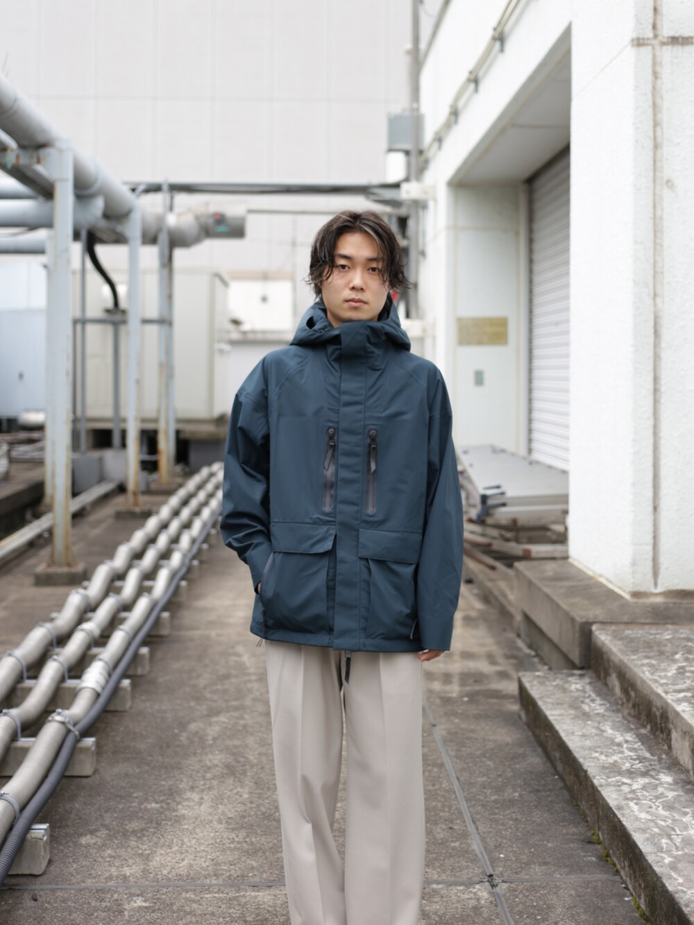 グリーン系のブルゾン、ベージュ系のスラックスを着用したメンズの秋コーディネートの3枚目の写真