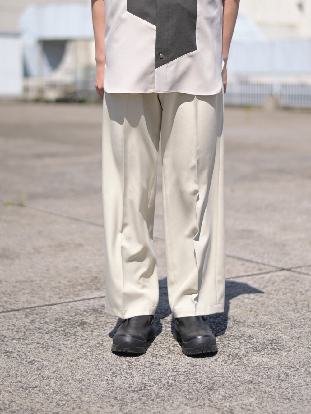 ベージュ系のスラックスを着用したメンズの夏コーディネートの4枚目の写真