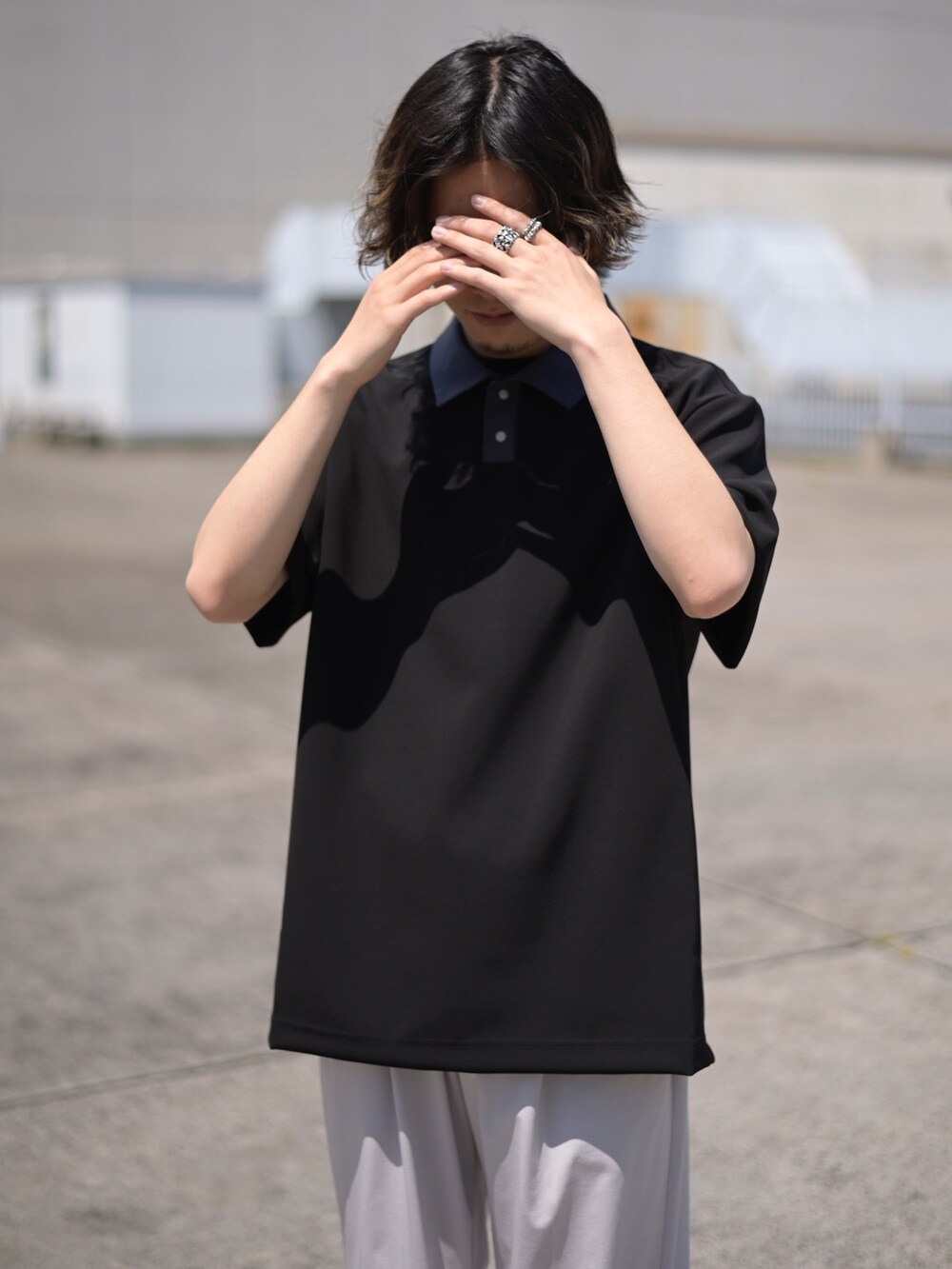 ブラック系のポロシャツを着用したメンズの春コーディネートの2枚目の写真