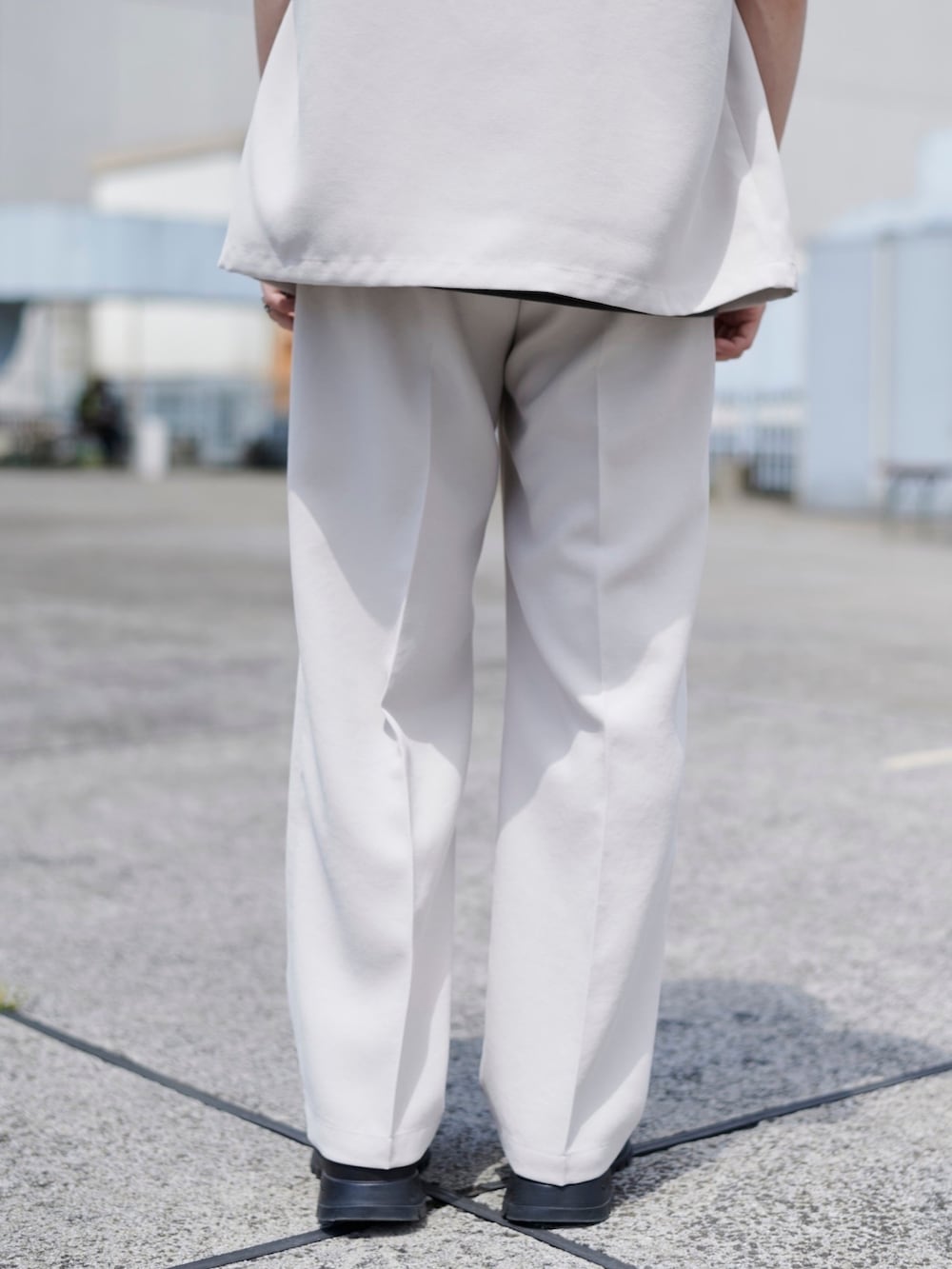 ホワイト系のテーラードジャケット、ホワイト系のスラックスを着用したメンズの春コーディネートの3枚目の写真