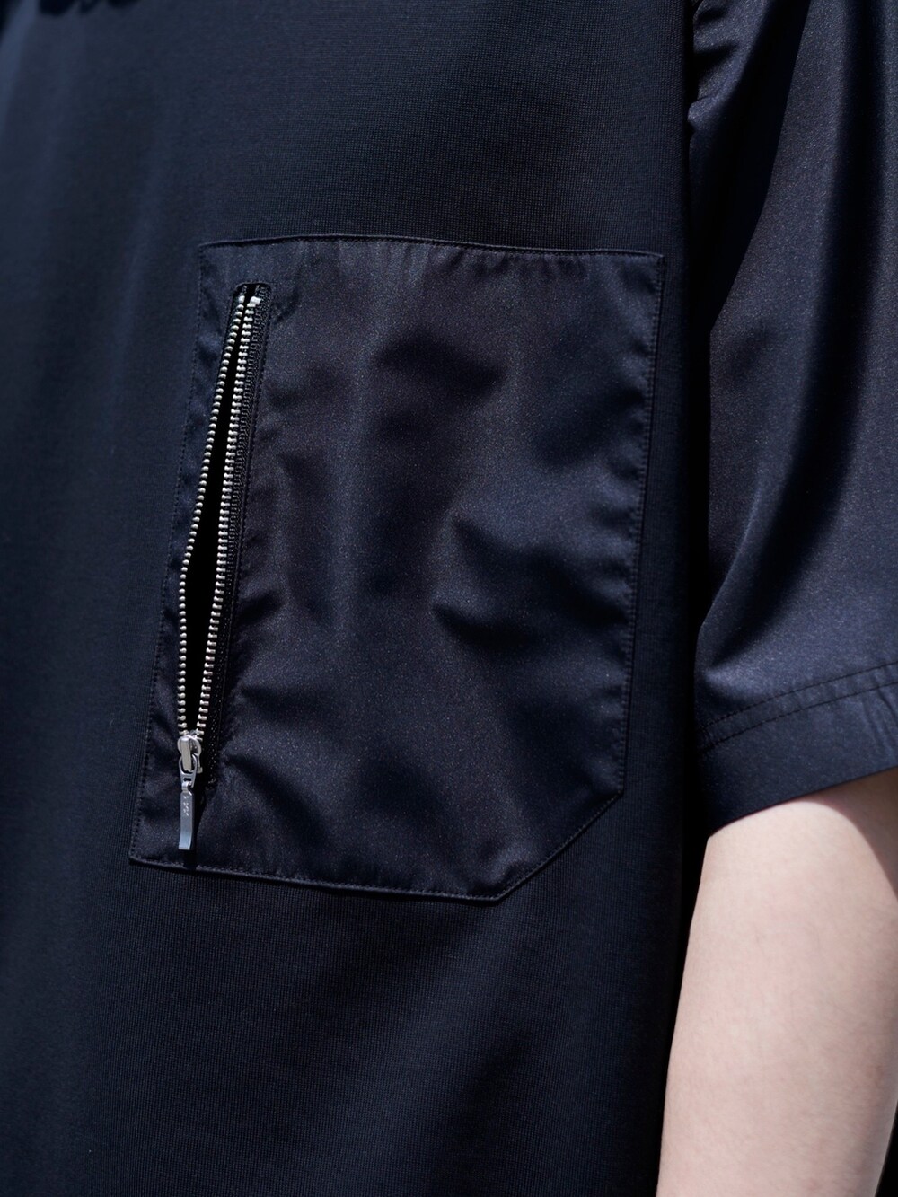 ブラック系のTシャツ/カットソーを着用したメンズの春コーディネートの6枚目の写真