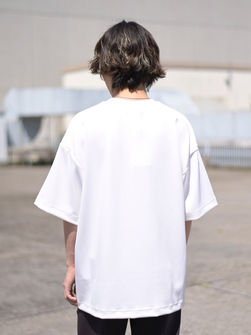 ホワイト系のTシャツ/カットソー、ブラウン系のスラックスを着用したメンズの春コーディネートの4枚目の写真